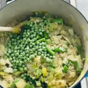 Stirring fresh asparagus, peas, and spinach into the creamyone-pot orzo risotto spring veggies