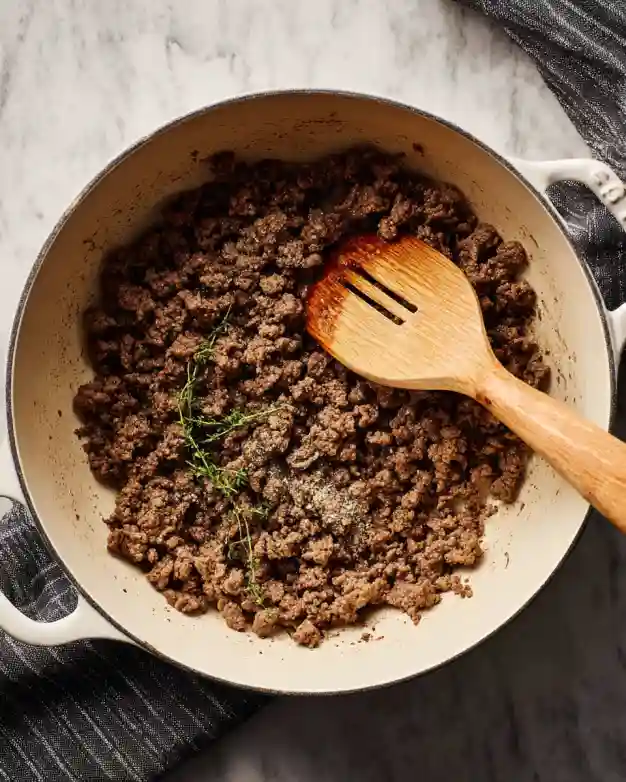 Ground beef browning in soup pot with spices