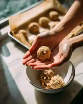 Hands forming chicken meatballs for one pot recipe