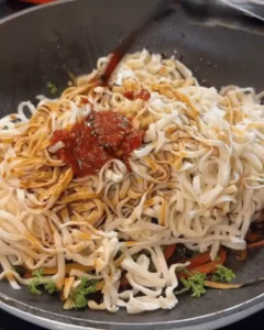 One Pan Chicken with Buttered Noodles Recipe: Adding noodles and sauce to the pan with vegetables