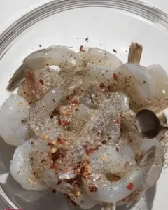 Raw shrimp seasoned with spices and pepper for One-Pan Salsa Verde Shrimp and Rice.