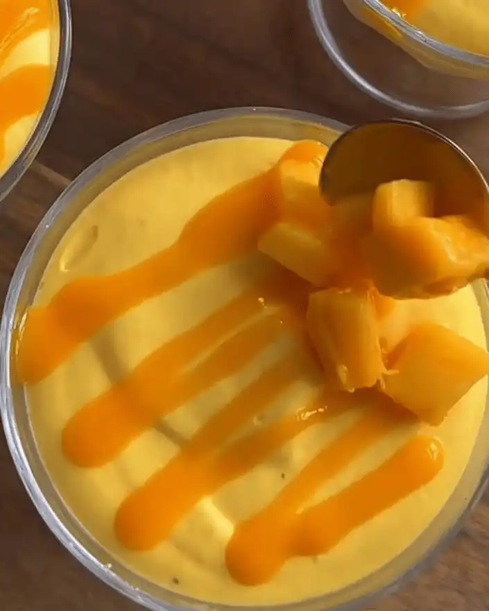 No bake mango cheesecake cups topped with diced mango and mango sauce