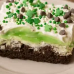 Slice of No Bake Shamrock Shake Dessert with Oreo crust and green pudding layer