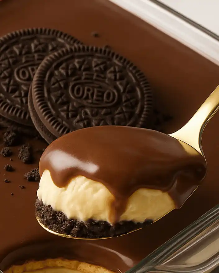 Spoonful of no bake Oreo dessert with cream and chocolate topping