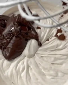 mixing melted chocolate into cream cheese filling for no-bake double chocolate cheesecake recipe