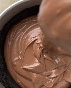 pouring chocolate filling into cookie crust for no-bake double chocolate cheesecake recipe