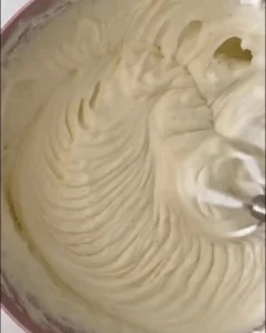 Creamy cheesecake filling being mixed until smooth and fluffy.