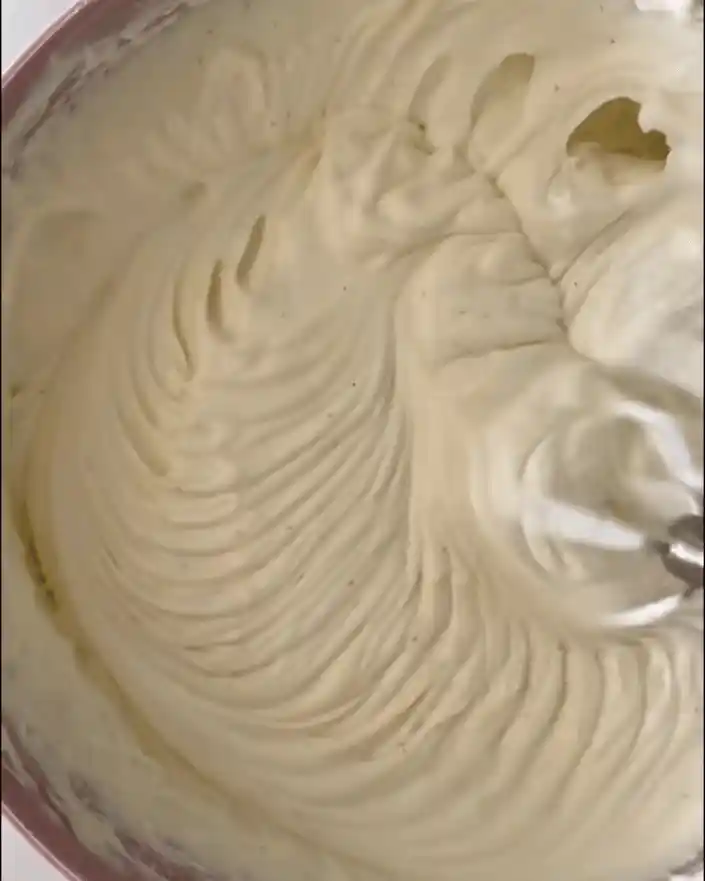 Creamy cheesecake filling being mixed until smooth and fluffy.