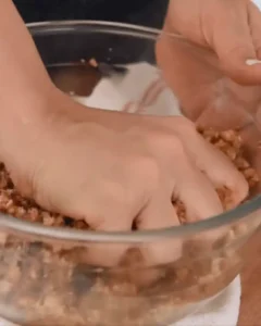 mixing pecan pie balls no bake dough by hand in bowl
