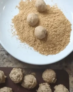 Rolling no bake moose farts in graham cracker crumbs