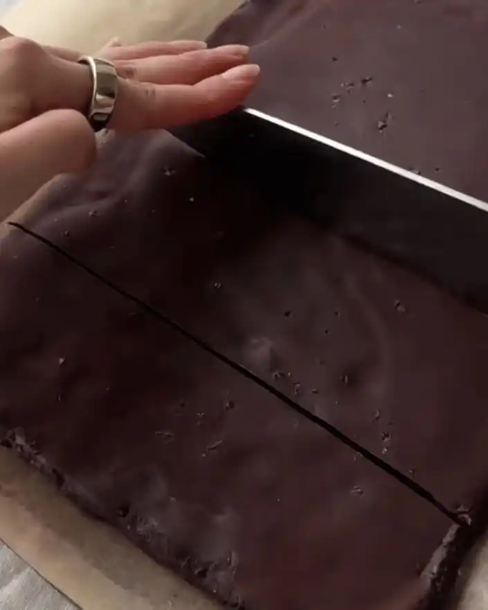 Cutting chilled no bake healthier brownies into bars with a knife