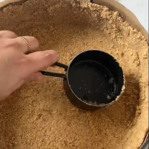 Pressing graham cracker crust into pan for No Bake Pistachio Cheesecake