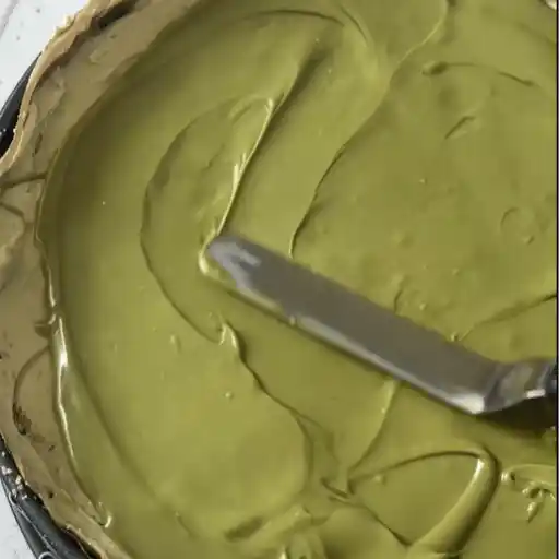 Spreading pistachio cream topping over No Bake Pistachio Cheesecake
